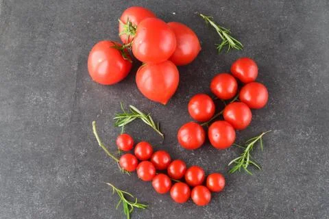 Different types of tomatoes on branches with rosemary and sea salt. Stock Photos
