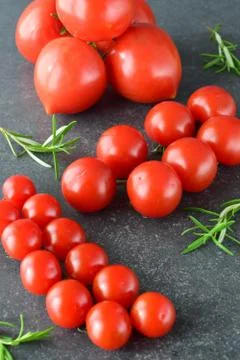 Different types of tomatoes on branches with rosemary and sea salt. Stock Photos