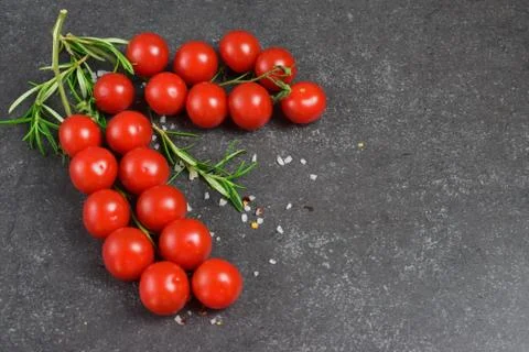 Different types of tomatoes on branches with rosemary and sea salt. Stock Photos