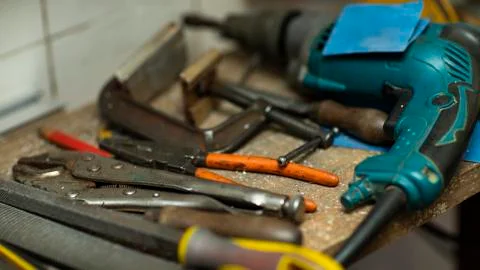 Different types of tools and hand drill on desktop. Stock Photos