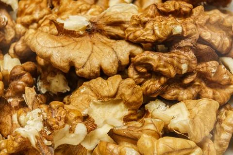 Different types of walnuts are displayed together in a close-up view on a wooden Stock Photos