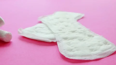 Different types of women's pads and tampons lie on a pink background. Koznept Stock Footage 252878719