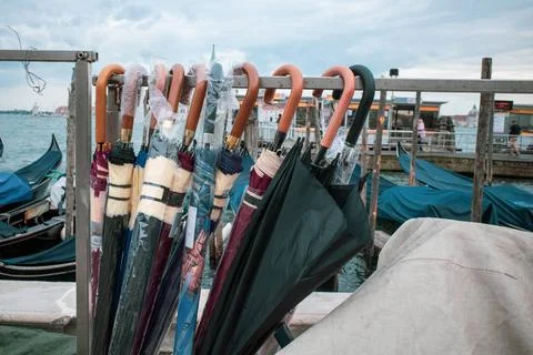 Different umbrellas hang side by side on a stand 스톡 사진