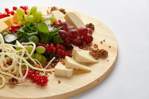 Different varieties of cheese with walnuts and grapes. Stock Photos