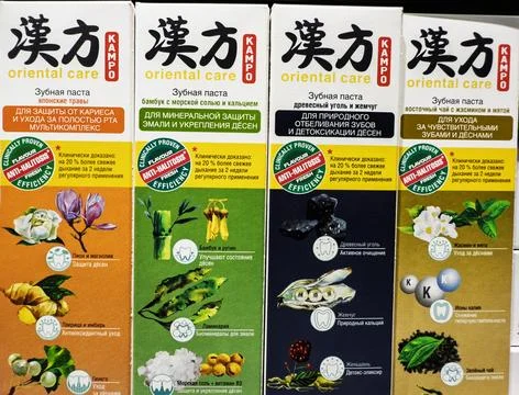 Different varieties of herbal toothpaste displayed on shelves in a store Stock-Fotos