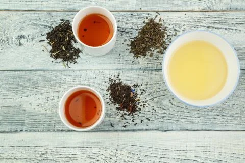 Different varieties of tea on the table and in tea glasses on a white shabby  Stock Photos