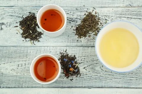 Different varieties of tea on the table and in tea glasses on a white shabby  Stock Photos