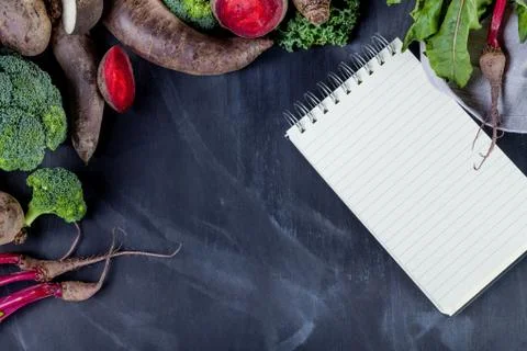 Different vegetables on black with notebook Stock Photos