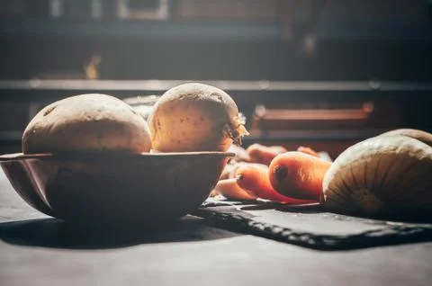 Different vegetables on a black table with midday soft sun light. Stock Photos