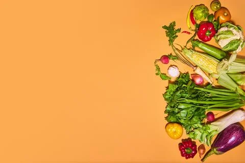 Different vegetables on orange background. Pumpkin, garlic, broccoli, onion Foto stock