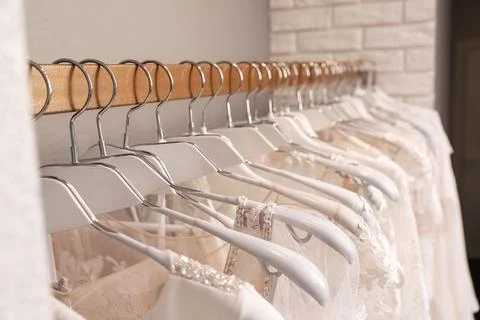 Different wedding dresses on hangers in boutique, closeup Stock Photos