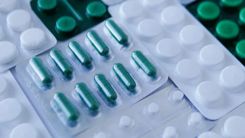Different white and green tablets lying on rotating table, testing factory 库存影片 239919754