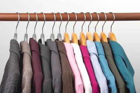Different women's office classic jackets and shirts hang on a hanger for stor Stock Photos