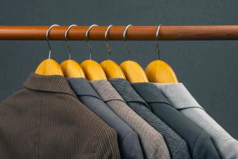 Different women's office classic jackets hang on a hanger for storing clothes Stock Photos