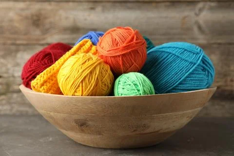 Different yarns and pattern sample in bowl on grey table, closeup Foto stock