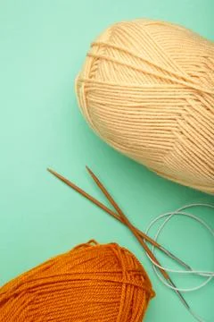 Different yarns, knitting needles on mint background. Autumn. Vertical photo Stock Photos