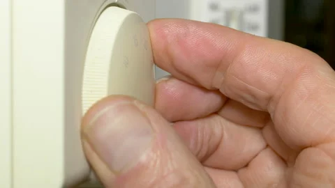 Differential focus – room thermometer - hand turning DOWN a heating thermostat. Video stock 171576097