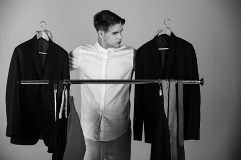 Difficult choice. jacket in hands of man choosing outfit, wardrobe, shopping Foto stock