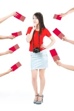Difficult choice. Many hands holding the red offers. A beautiful young woman  Stock Photos