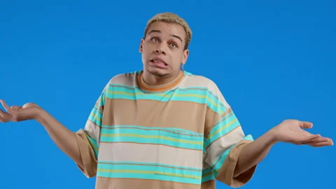 Difficult question, guilty reaction, puzzled stylish guy on blue background Stock Footage 222986581