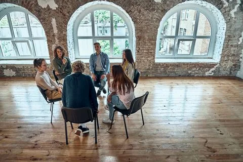 Difficult youth talking to a therapist while sitting in a circle during a mee Stock Photos