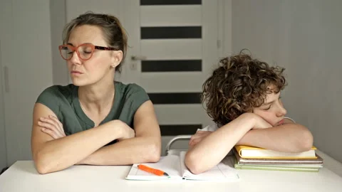 Difficulties of home schooling. Mom is trying to help her son with lessons. Lack Stock Footage 134827926