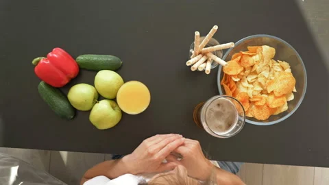 Difficulty of choosing between a healthy and unhealthy diet. Woman chooses food Video stock 130943340