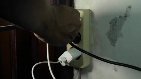 Difficulty installing the smartphone charger in the power outlet Stock Footage 241051383