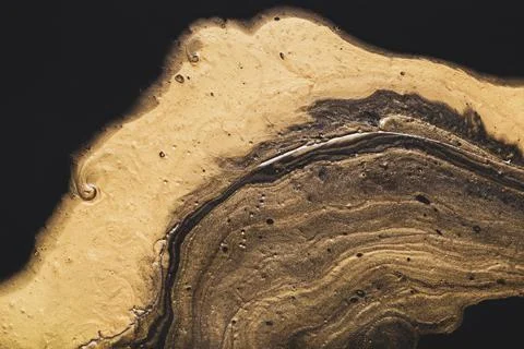 Diffuse liquid gold on black. Golden wave and bubbles. Abstract liquid marble Stock Photos