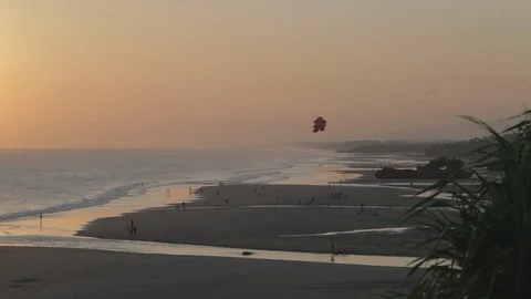 Diffuse sunset on the beach, with parachute flying through the air. Stock Footage 99856860