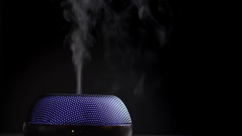 Diffuser for essential oils diffusing steam on black background Stock Footage 122694263