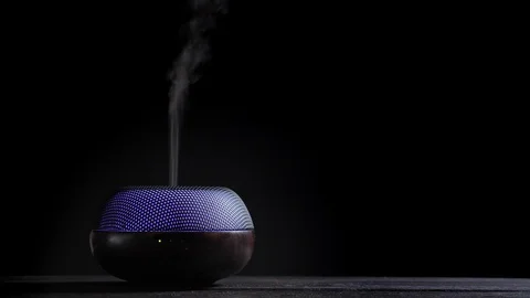 Diffuser for essential oils diffusing steam on black background Video stock 122694293