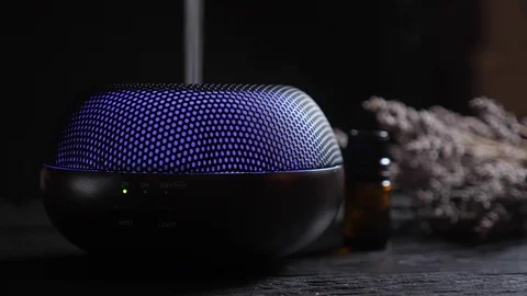Diffuser for essential oils diffusing steam on black background Video stock 122695076