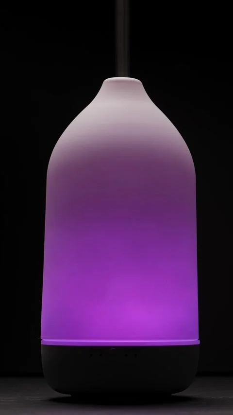 Diffuser with purple light diffusing steam on black background. Closeup Video stock 327208485