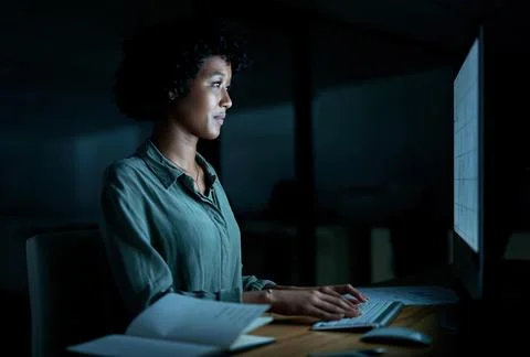 Dig deep and get things done. a young businesswoman using a computer during a 스톡 사진