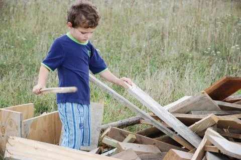 Dig for usable Ein Kind sucht nach passendem Holz ,model released, Symbolf... Fotos de archivo