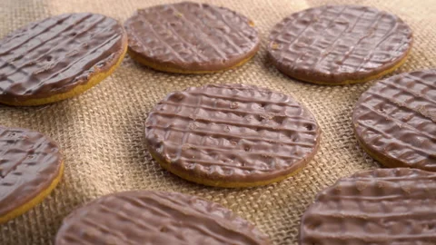 Digestive biscuits coated with dark chocolate on a rough rural sackcloth Stock Footage 160737695
