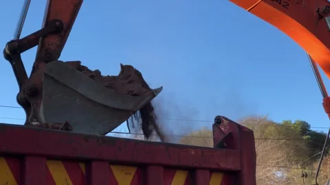 Digger bucket scooping up rubble dumping into dump truck. Hand held. Video stock 252343808