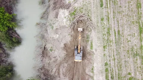 Digger cleans river embankment from tree trunks and branches Stock-Footage 154252273