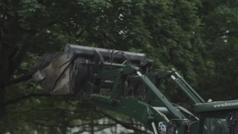 Digger excavating and moving earth. Emptying bucket into truck. Stock Footage 93207649