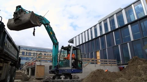 Digger Loading Ground and Pouring it in an Office Building Site. Stock Footage 95856104