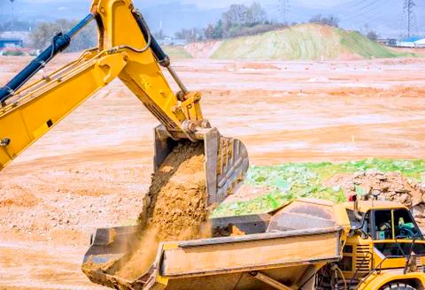 Digger loading a trailer on construction site. Stock-Fotos