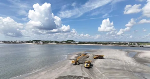 A digger loads sand onto trucks for a dune replenishment project 動画素材 254798360