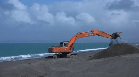 Digger piles shingle on beach timelapse  Stock Footage 42562903
