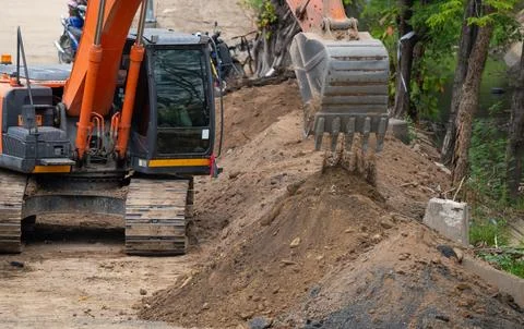 Digger working by digging soil at construction site. Bucket teeth of backho.. Stock-Fotos