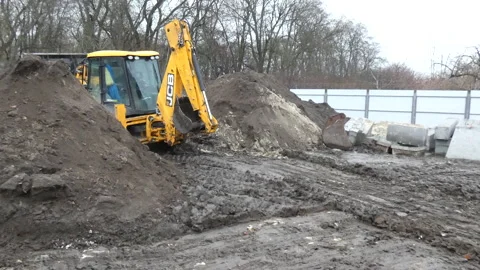 Digger working  in the mud and  clearing out the land, rides back 4k video Stock Footage 169753101