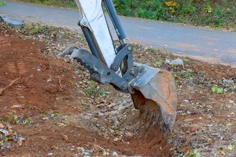 Digging ditch with tractor to accommodate drainage concrete sewage pipe Stock Photos