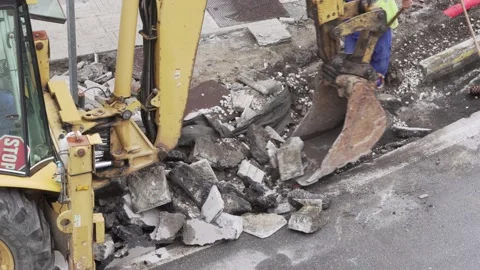 Digging Machine bucket loading debris of the sidewalk and road on reparation Video stock 139978484