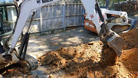 Digging a trench with a Bobcat backhoe 4K Stock Footage 93748925