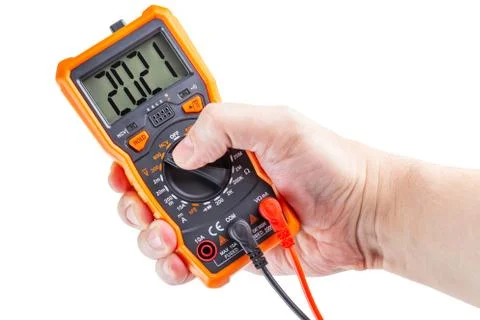 Digit 2021 on lcd screen of digital electrical multimeter in left hand, isola Stock Photos